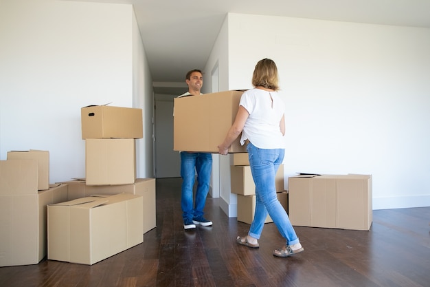 Free Photo married couple leaving apartment, carrying cartoon box to entrance together