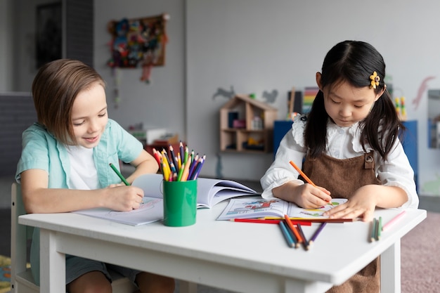 Free Photo medium shot kids coloring at table