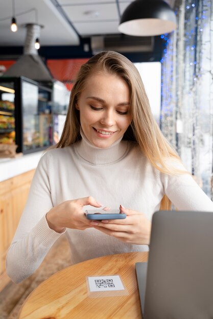 Free photo medium shot smiley woman holding phone