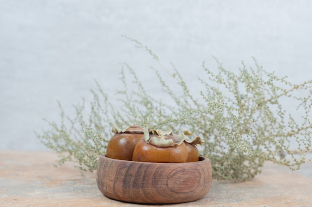 Free Photo medlar fruit in bowl with grass on marble table.