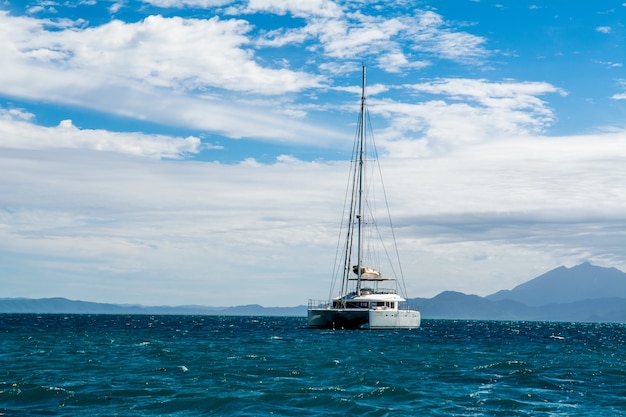 Foto gratuita scenario affascinante di uno yacht sul mare blu con nuvole bianche sullo sfondo