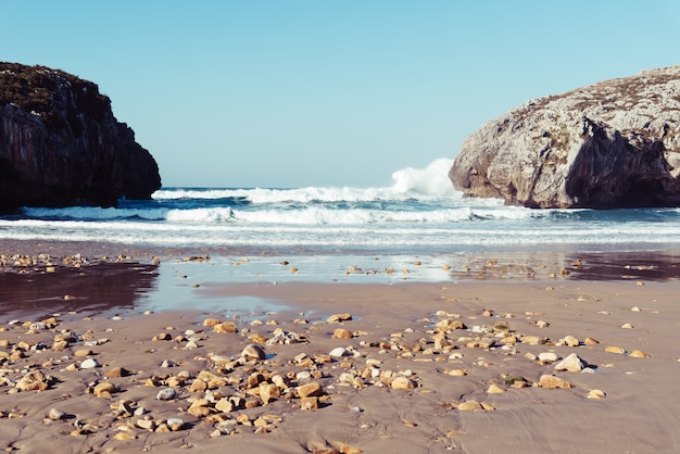 Free photo mesmerizing view of the ocean waves crashing on the rocks on a clear day