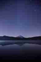 Free photo mesmerizing view of the reflection of the mountain on the lake under the starry night sky