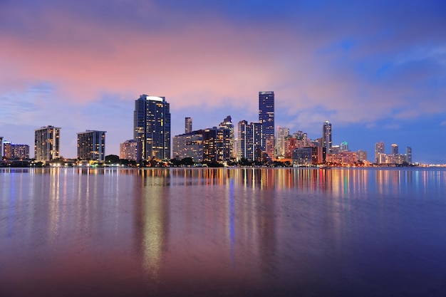 Free photo miami city skyline panorama at dusk with urban skyscrapers over sea with reflection