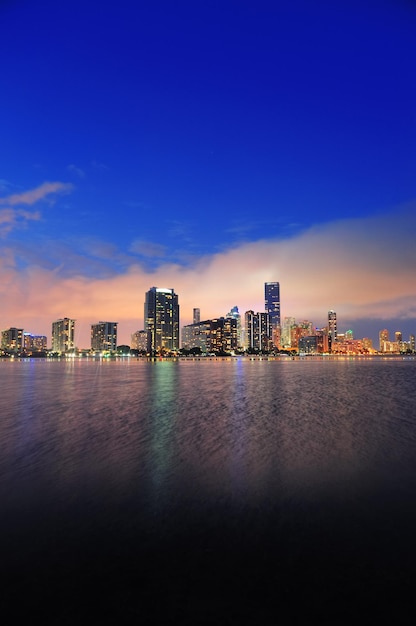 Free photo miami city skyline panorama at dusk with urban skyscrapers over sea with reflection