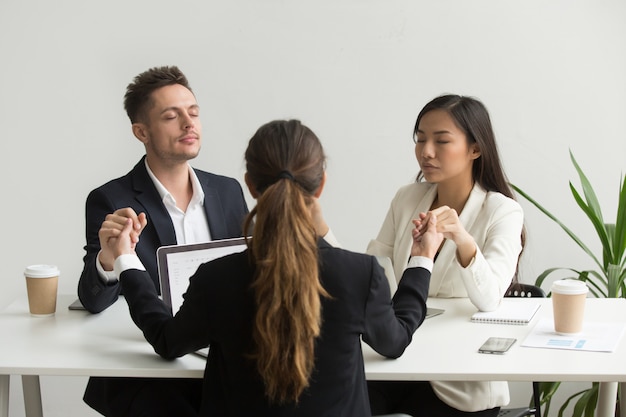 Free Photo mindful diverse team people holding hands meditating praying for success