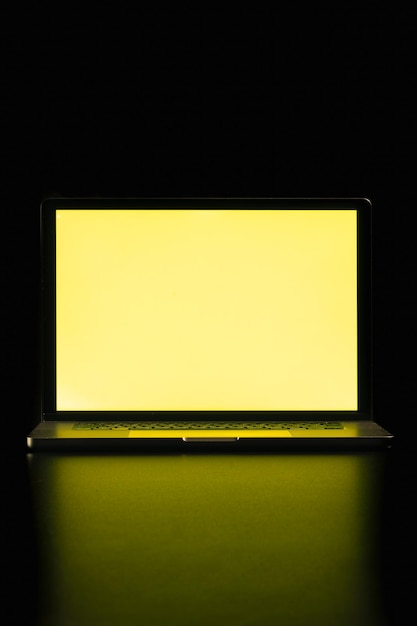 Free photo modern laptop with blank yellow screen isolated on black background close up