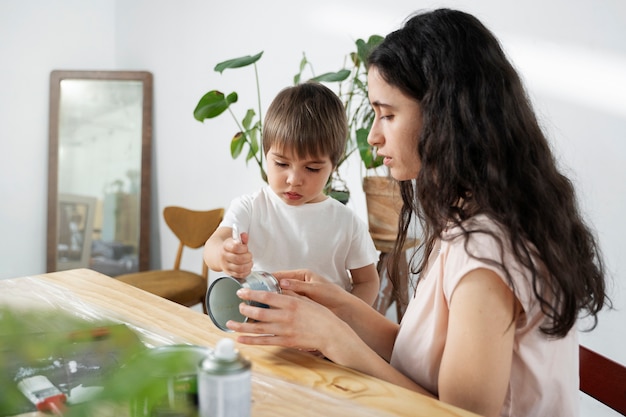 Foto gratuita mamma che mostra al bambino come riutilizzare i materiali in modi creativi