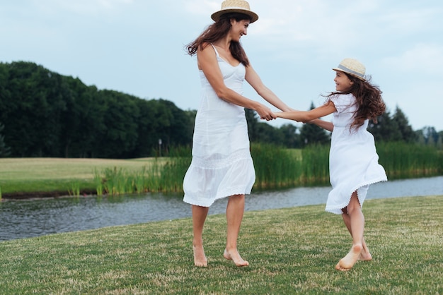 Free photo mother and daughter having fun by the lake