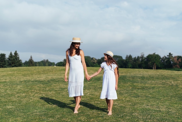 Free photo mother and daughter holding hands outdoors