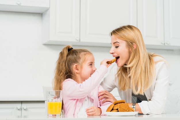 Free photo mother and daughter with cookies and juice