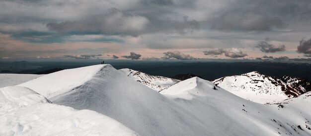 Mountains covered in snow under a cloudy sky