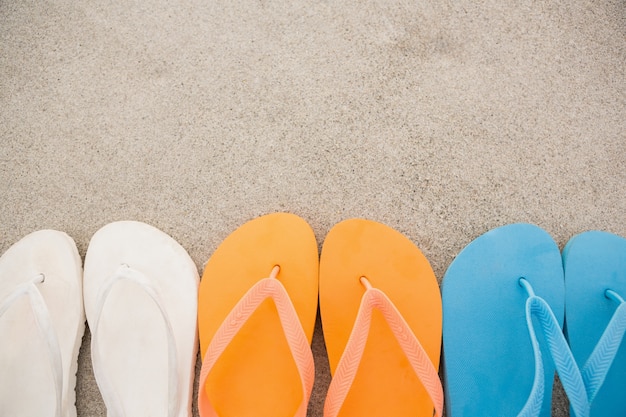 Free photo multi-color flip flops arranged in a row in sand