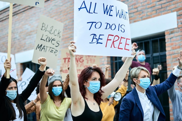 Free photo multiethnic crowd of people wearing protective face mask while taking a part in black lives matter protest