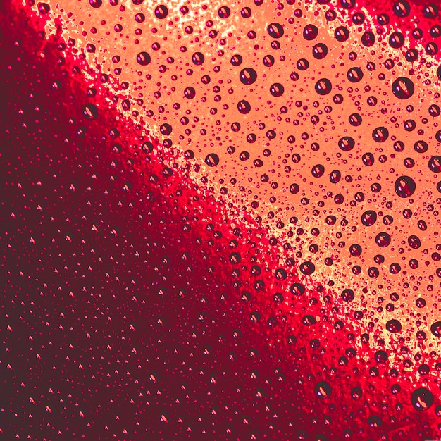 Free photo natural pattern of water drops on red and an orange background