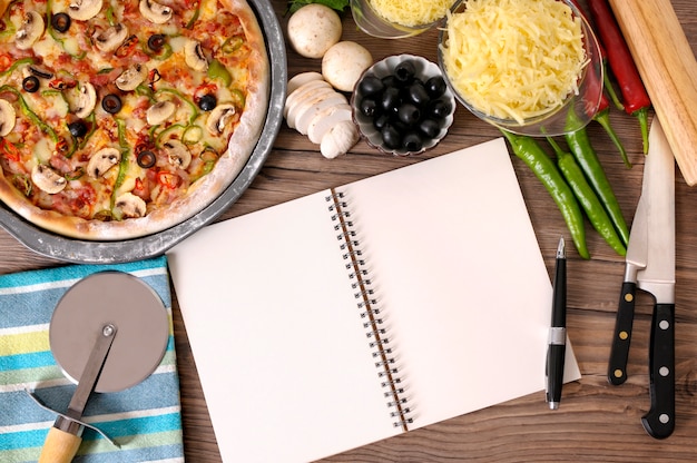 Free Photo notebook and pizza above the table