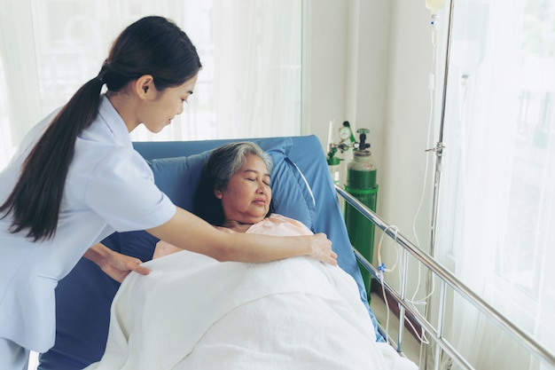 Free photo the nurses are well good taken care of elderly woman patients in hospital bed patients  feel happiness - medical and healthcare concept