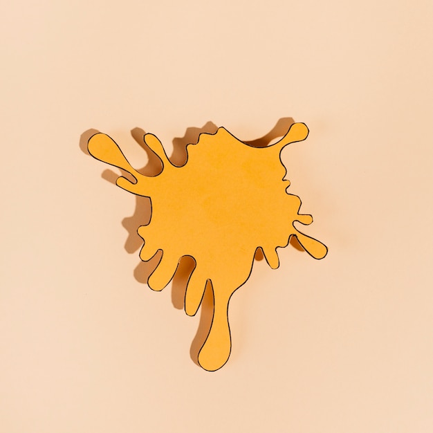 Free photo an orange empty cutout splash on beige background