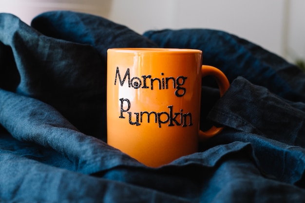 Free Photo orange mug on black cloth