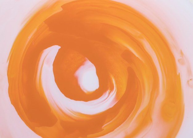 Free photo orange paint brush strokes forming circular shape over white canvas