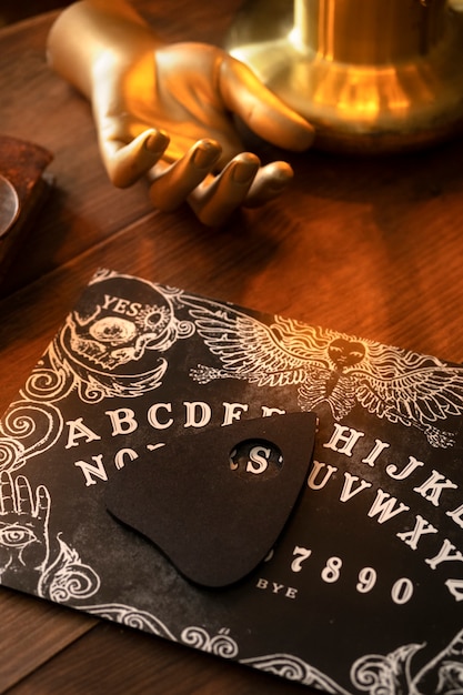 Free photo ouija board and golden hand arrangement