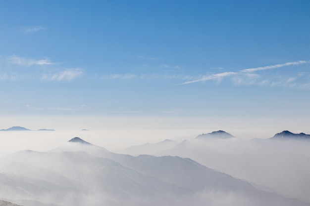 Free photo overlooking view of a mountain range covered with a white fog