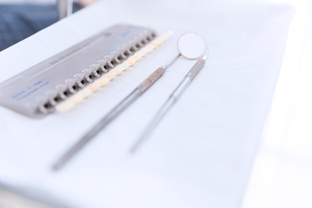 Palette of teeth shades with dental mirror and probe on desk