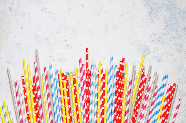 Free photo paper straws of different colors on light tablewith