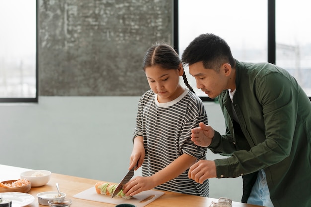 Free Photo parent teaching kid how to make sushi