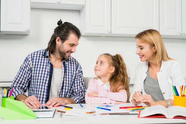 Free photo parents and daughter coloring together