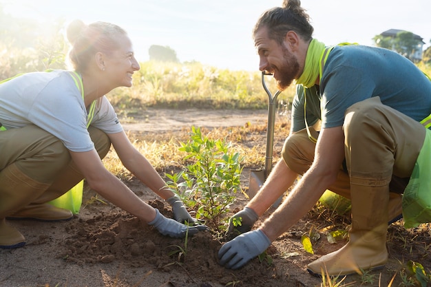 Free photo people planting tree on the countryside