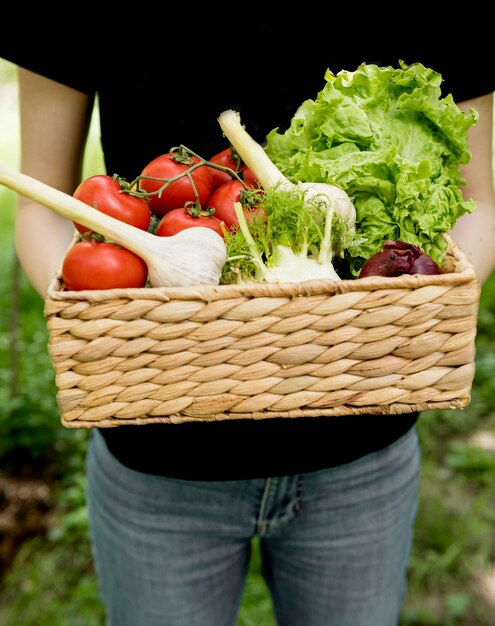 Person holding bucket with veggies