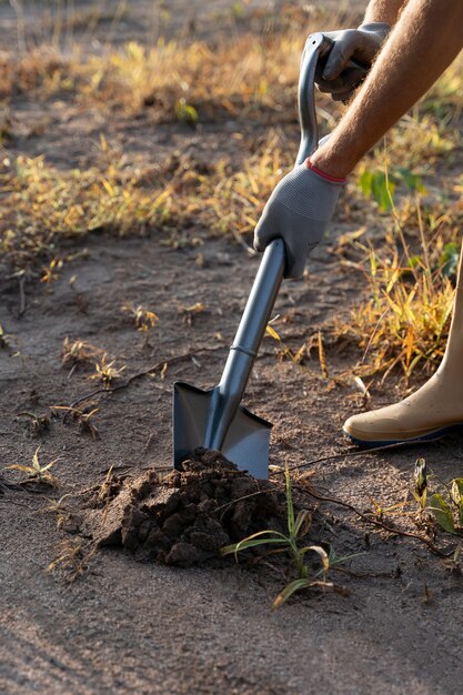 Free photo person planting tree on the countryside