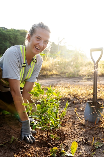 Free photo person planting tree on the countryside