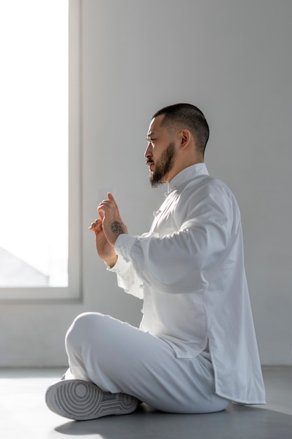 Free photo person practicing tai chi indoors