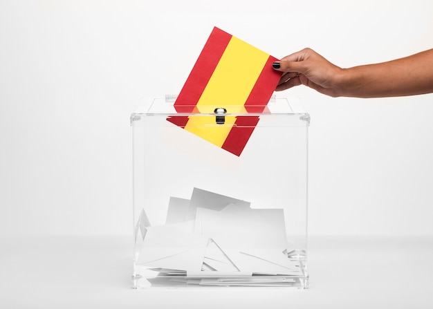 Person putting spain flag card into ballot box