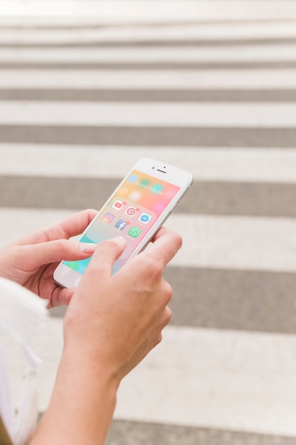 Person's hand holding cellphone with social media notifications on screen