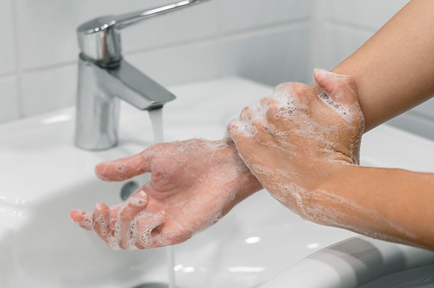 Free photo person washing wrist with soap