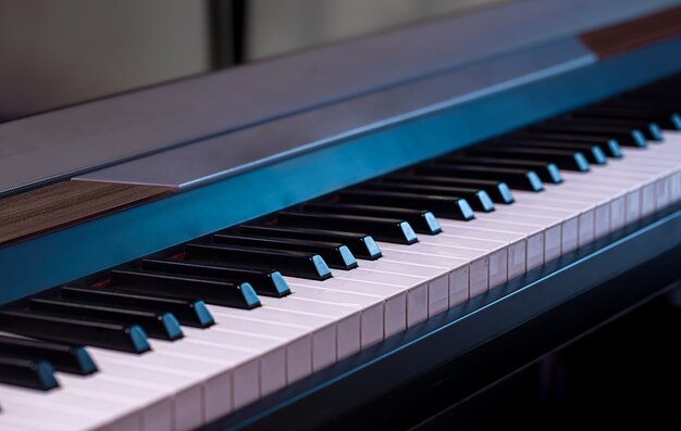 Piano keys on a beautiful colored background close up.