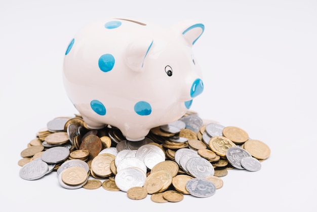 Free Photo piggybank over many coins on white background