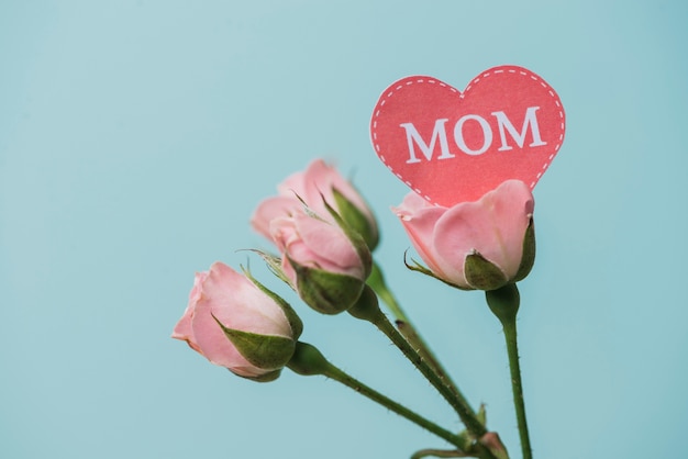 Free photo pink flowers with paper heart for mother's day