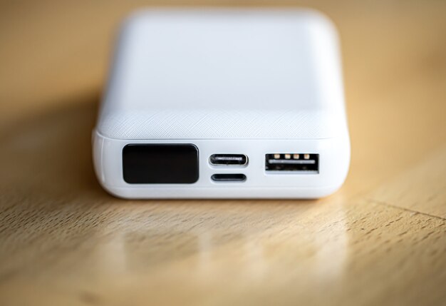 Portable power bank for smartphone, small white power bank, close up.