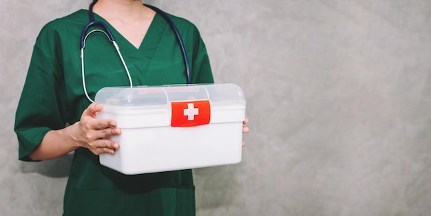 Foto gratuita medico donna asiatica del ritratto che indossa uniforme che trasporta il kit della cassetta di pronto soccorso con lo sfondo dello spazio della copia