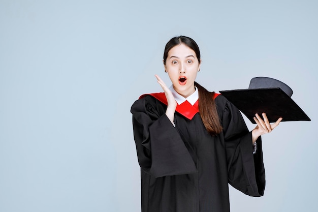 Free photo portrait of beautiful woman in graduation outfit feeling surprised. high quality photo