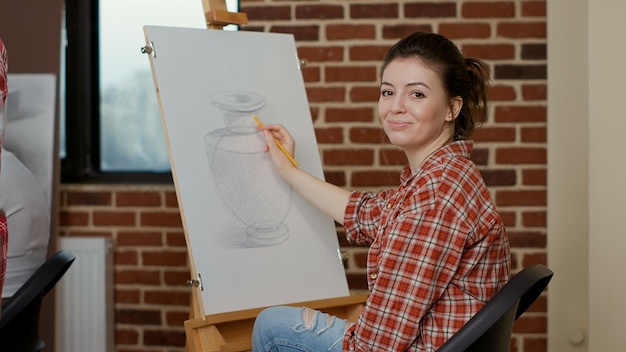 Free photo portrait of creative woman attending art class program to draw professional sketch on canvas. artistic classroom to teach drawing skills and technique on paper as new years resolutions.