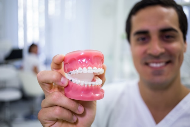 Portrait of dentist holding a set of dentures