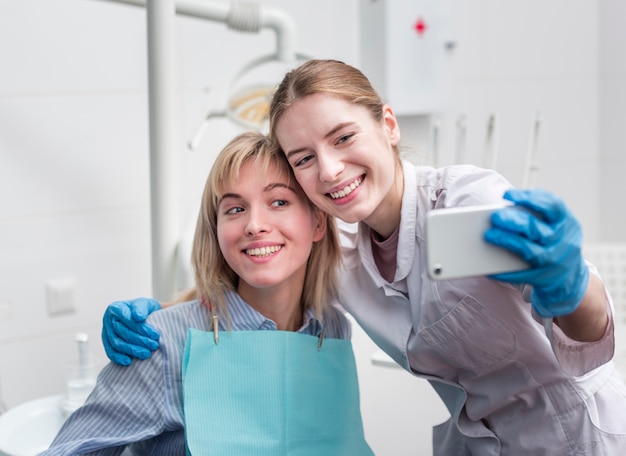 Foto gratuita ritratto del dentista che prende un selfie con il paziente