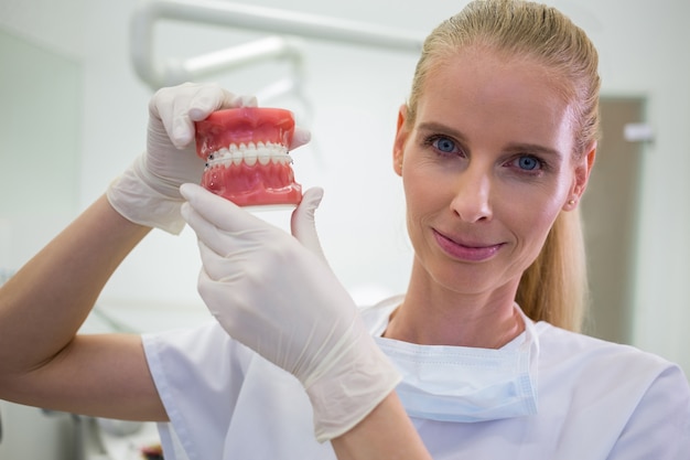 Free photo portrait of female dentist holding a set of set of dentures