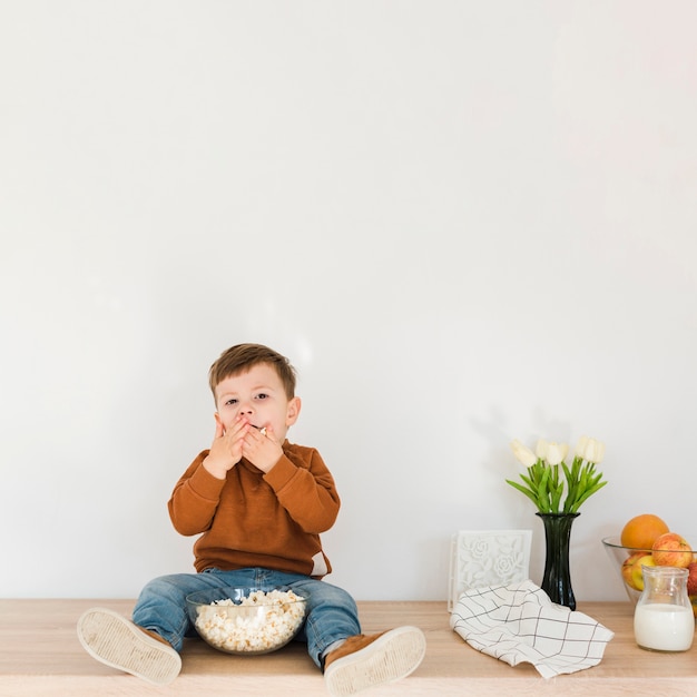 Foto gratuita ragazzino del ritratto che mangia popcorn