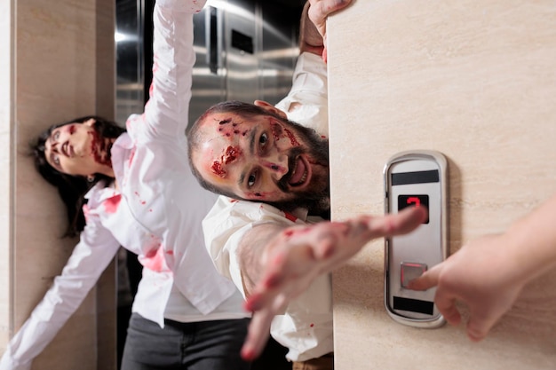 Free Photo portrait of man zombie attacking office, escaping elevator and looking dangerous with bloody scars. eerie aggressive monsters being terrifying and chasing after people, brain eating walkers.